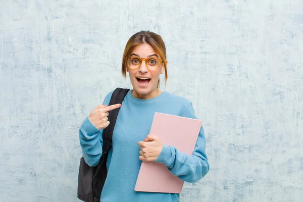 Młody Student Kobieta Patrząc Zszokowany Zaskoczony Usta Szeroko Otwarte Wskazując — Zdjęcie stockowe