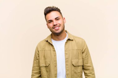 İri, dost canlısı, kaygısız gülüşü olan genç İspanyol adam, pozitif, rahat ve mutlu görünüyor, izole edilmiş arka planda takılıyor.