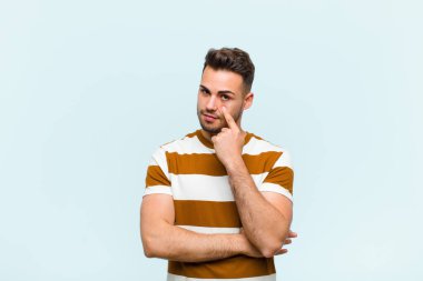 Genç İspanyol adam sana göz kulak oluyor, güvenmiyor, izliyor ve mavi duvara karşı tetikte.