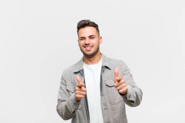 Genç İspanyol adam kendini mutlu, sakin, tatmin olmuş, rahat ve başarılı hissediyor, kameraya bakıyor, gri arka planda seni seçiyor.