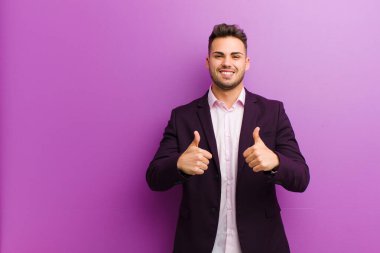 Genç İspanyol adam neşeyle gülümsüyor ve mutlu görünüyor, kaygısız ve pozitif hissediyor.