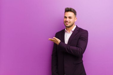 Genç İspanyol adam neşeyle gülümsüyor, mutlu hissediyor ve fotokopi uzayda bir kavram gösteriyor.