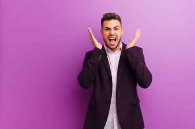 Genç İspanyol bir adam beklenmedik bir sürprizden dolayı şaşkın, heyecanlı, gülen, şaşkın ve mutlu hissediyor.