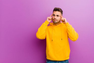 Mor arka planda sıradan görünüşlü genç bir İspanyol.