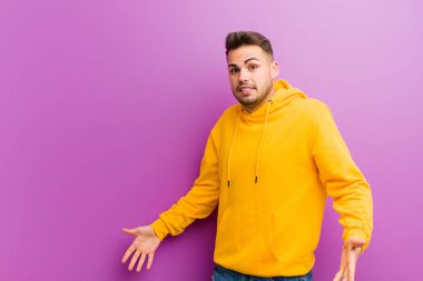 Mor arka planda sıradan görünüşlü genç bir İspanyol.