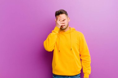 Mor arka planda sıradan görünüşlü genç bir İspanyol.