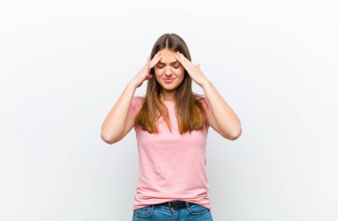 Genç ve güzel bir kadın stresli ve hayal kırıklığına uğramış görünüyor. Baskı altında çalışıyor ve beyaz arka planda sorunlar yaşıyor.