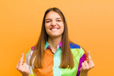 Genç, güzel bir kadın kışkırtıcı, agresif ve müstehcen hissediyor. Orta parmağını hareket ettiriyor. Düz arkaplan karşısında asi bir tutum sergiliyor.