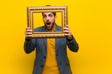 Portakal rengi sırt grubuna karşı barok çerçeveli genç yakışıklı adam.