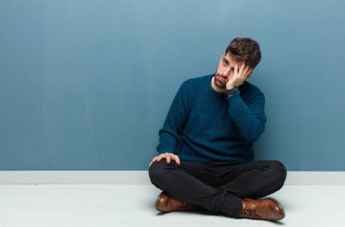 Genç ve yakışıklı bir adam yerde oturuyor. Sıkılmış, hayal kırıklığına uğramış ve uykulu. Yorucu, sıkıcı ve can sıkıcı bir işin ardından.