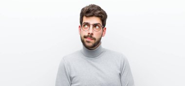 Şaşırmış, gergin, endişeli ya da korkmuş bakışları olan genç bir yönetici beyaz duvara karşı fotokopi odasına bakıyor.