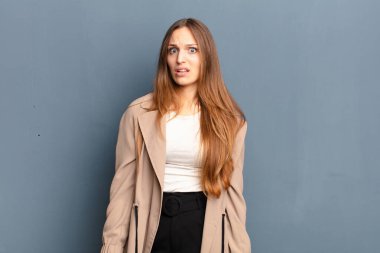 Şok olmuş, kızgın, sinirli ya da hayal kırıklığına uğramış, ağzı açık ve öfkeli görünen genç bir kadın.