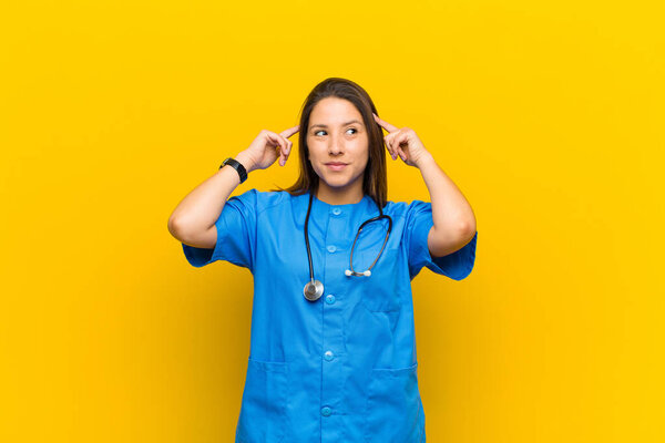 feeling confused or doubting, concentrating on an idea, thinking hard, looking to copy space on side isolated against yellow wall