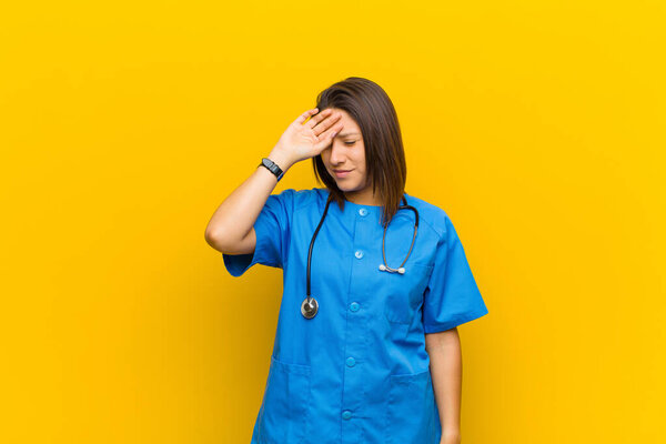 looking stressed, tired and frustrated, drying sweat off forehead, feeling hopeless and exhausted isolated against yellow wall