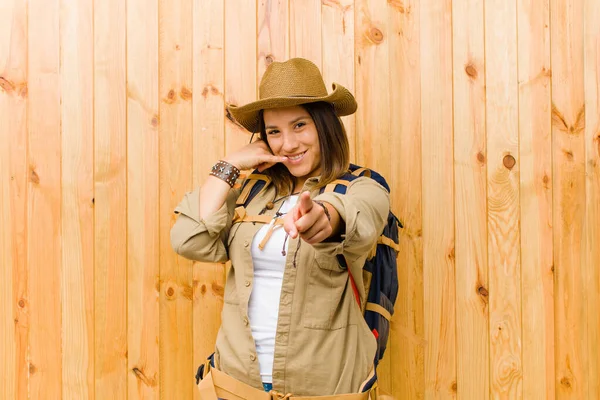 young latin explorer woman against wooden wall background