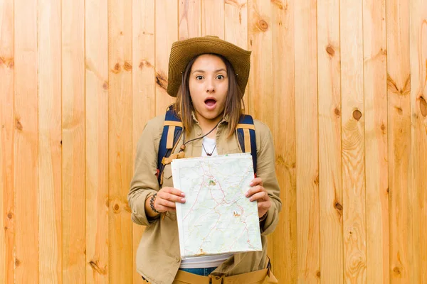 Junge Frau mit Landkarte gegen Holzwand — Stockbild Junge Frau Mit Landkarte Gegen Holzwand — Stockfoto