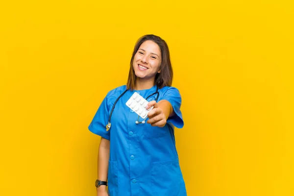 オレンジの壁に枕を持つ看護師の女性 — ストック写真