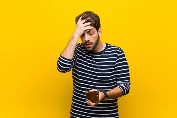 Jovem homem bonito contra fundo laranja — Fotografia de Stock