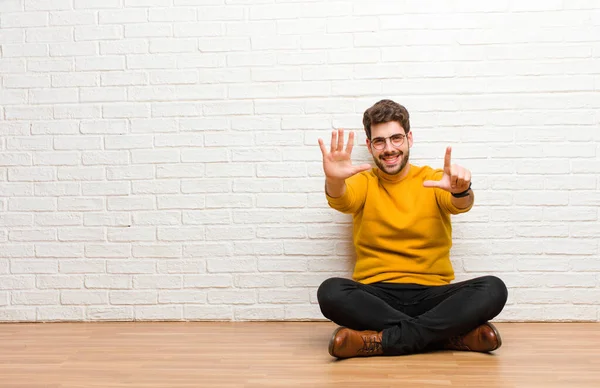 Jovem Homem Bonito Sentado Chão Casa Contra Textura Parede Tijolo — Fotografia de Stock