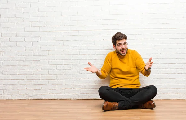 Jonge Knappe Man Zitten Vloer Tegen Baksteen Muur Textuur — Stockfoto