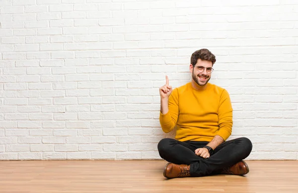 Jonge Knappe Man Zitten Vloer Tegen Baksteen Muur Textuur — Stockfoto