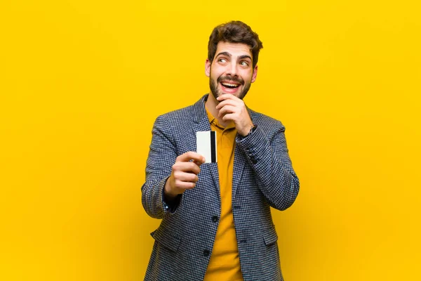 Jovem homem bonito contra fundo laranja — Fotografia de Stock