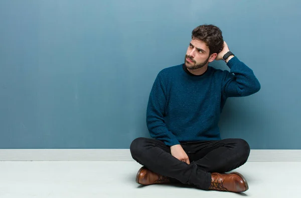 Young Handsome Man Sitting Floor Feeling Puzzled Confused Scratching Head — Stock Photo, Image