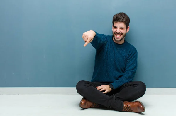 Jonge Knappe Man Die Vloer Zit Uitlacht Naar Camera Wijst — Stockfoto