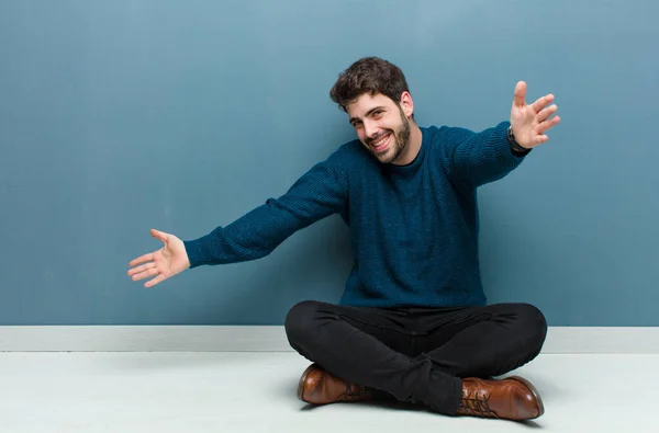 Jovem Homem Bonito Sentado Chão Sorrindo Alegremente Dando Abraço Boas — Fotografia de Stock