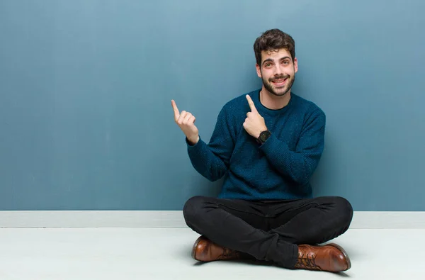 Jovem Homem Bonito Sentado Chão Sorrindo Feliz Apontando Para Lado — Fotografia de Stock