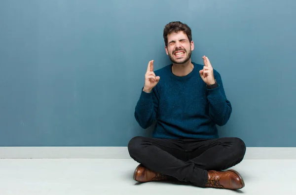 Jonge Knappe Man Zit Vloer Glimlachend Angstig Kruisen Beide Vingers — Stockfoto