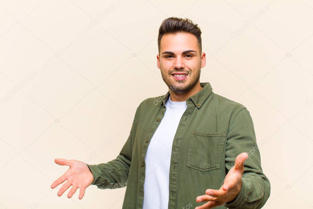 young hispanic man looking happy, arrogant, proud and self satisfied, feeling like a number one against isolated background