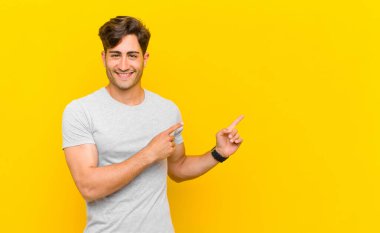  Gülümseyen ve her iki elinle yukarı ve yana doğru gösteren nesne kopyalama boşluğunda