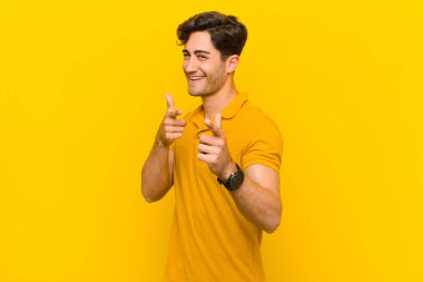  Pozitif, başarılı, mutlu bir tavırla kamerayı işaret ederek, elleriyle silah işareti yaparak.