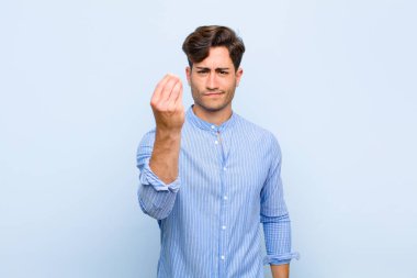 Genç yakışıklı adam sana borcunu ödemeni söyleyerek kapiş ya da para hareketi yapıyor! mavi arkaplan