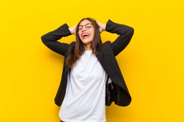 Genç ve güzel bir kadın gülümsüyor ve rahatlıyor, tatmin oluyor, kaygısız, pozitif gülüyor ve turuncu duvara karşı ürperiyor.