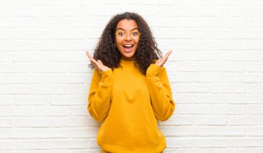 Genç siyahi kadın mutlu ve heyecanlı görünüyordu. Beklenmedik bir sürprizle sarsılmıştı. İki eli tuğla duvarın yanında açıktı.