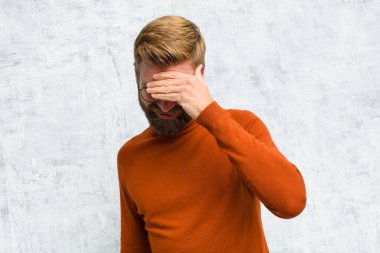 Stresli, utanmış ya da üzgün görünüyordu. Baş ağrısı vardı. Yüzü elle kaplıydı.