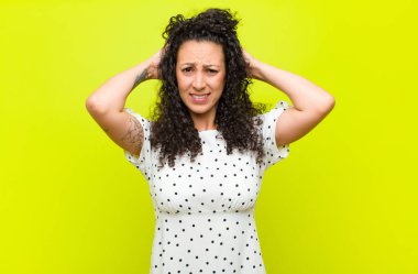 Genç, güzel bir kadın stresli, endişeli, endişeli ya da korkmuş, elleri başının üstünde, kroma anahtarına karşı yanlışlıkla panikliyor.