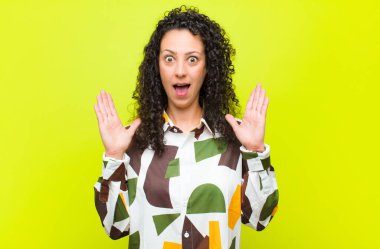 Genç ve güzel bir kadın şok olmuş ve şaşırmış görünüyor, chroma anahtar duvarına karşı inanılmaz bir şey fark ettiğinde çene şaşkın ve şaşırmış