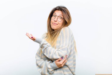 Genç ve güzel bir kadın, kafası karışık ve bilgisiz hissediyor, şüpheli bir açıklamayı merak ediyor ya da beyaz arka plan hakkında düşünüyor.