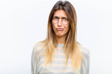 Genç, güzel bir kadın, kafası karışık ve şüpheli hissediyor, merak ediyor ya da beyaz arka plana karşı karar vermeye çalışıyor.