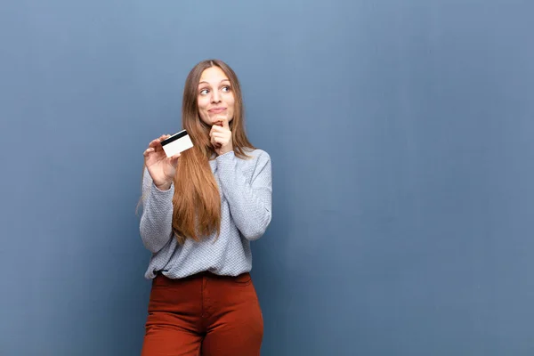 Joven Bonita Mujer Con Una Tarjeta Crédito Contra Pared Azul — Foto de Stock