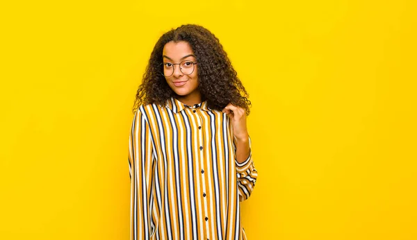 年轻而漂亮的非洲裔美国女人看上去骄傲自满 积极向上 骄傲自满 指指点点自己站在黄色的墙上 — 图库照片