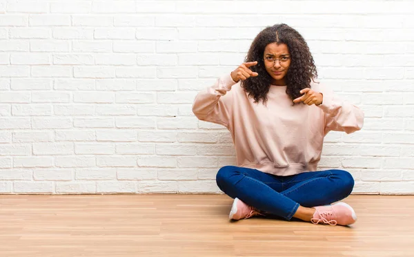 young african american black woman pointing forward at camera with both fingers and angry expression, telling you to do your duty