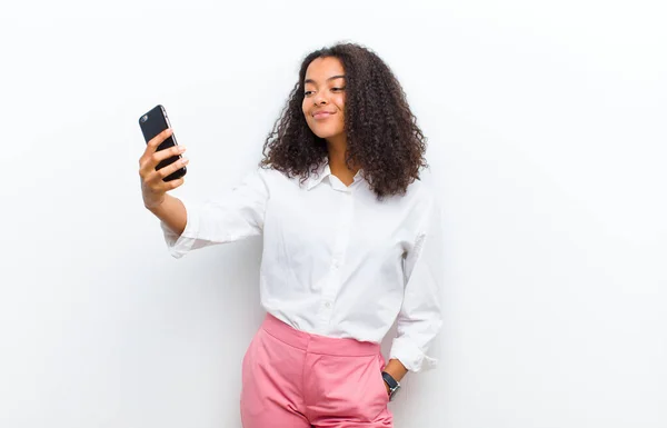 Beyaz Duvarda Akıllı Bir Telefonu Olan Genç Güzel Siyah Bir — Stok fotoğraf