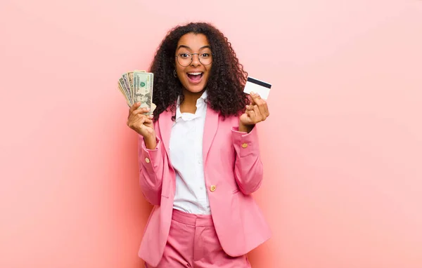 young black pretty woman with dollar banknotes against pink wall background