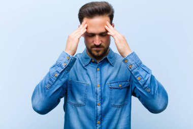 Genç ve yakışıklı bir adam stresli ve hayal kırıklığına uğramış görünüyor. Baskı altında çalışıyor ve sorunları var.