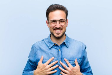 Genç yakışıklı adam mutlu görünüyor, şaşırmış, gururlu ve heyecanlı, kendini gösteriyor.