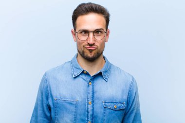 Genç ve yakışıklı adam şapşal ve komik görünüyor. Şaşı bakışlı, şakacı ve şakacı.